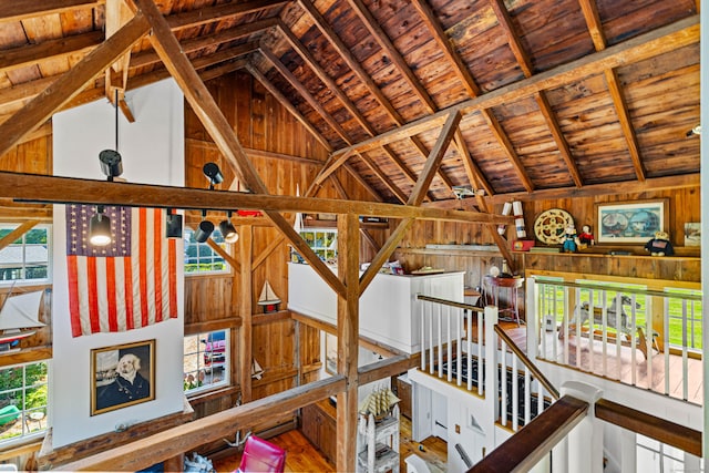 interior space with beam ceiling, wood ceiling, and wooden walls