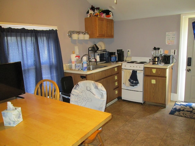 kitchen with lofted ceiling, sink, tile patterned floors, and white stove