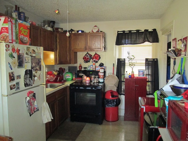 kitchen featuring a textured ceiling, white fridge, sink, and electric range