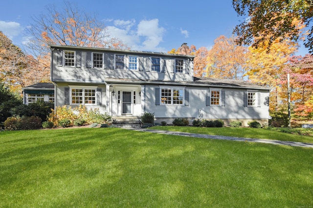 colonial home with a chimney and a front lawn