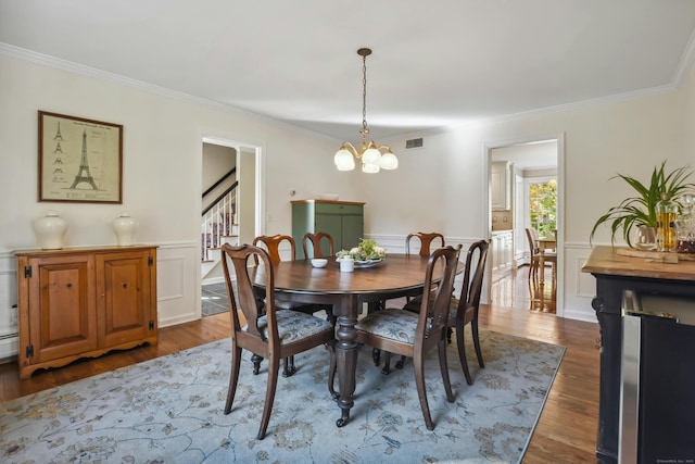 dining room featuring stairs, visible vents, dark wood-style flooring, and ornamental molding