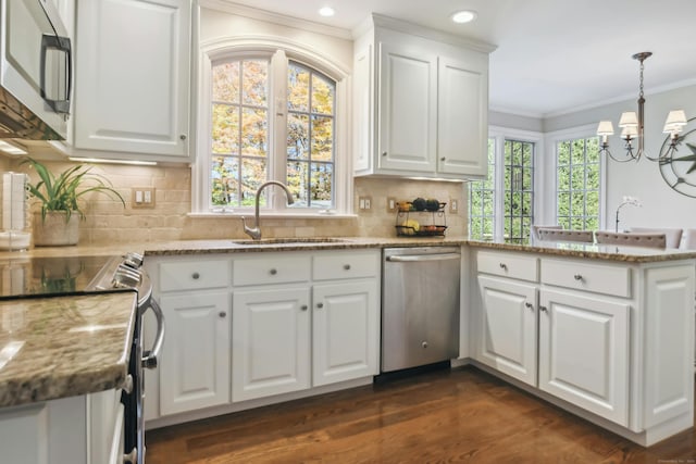 kitchen featuring stone counters, a peninsula, a sink, white cabinetry, and appliances with stainless steel finishes