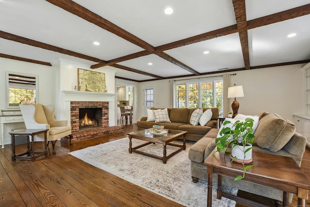 living room featuring a healthy amount of sunlight, dark wood finished floors, and beam ceiling