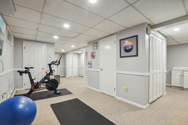 exercise area with a drop ceiling, recessed lighting, light colored carpet, and baseboards