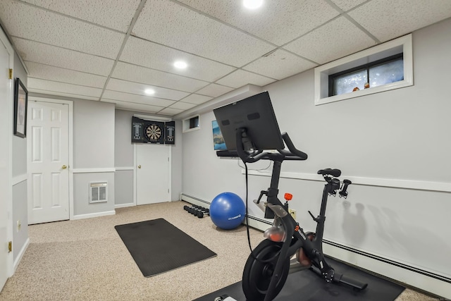 exercise area with visible vents, a baseboard heating unit, and baseboards