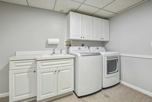 laundry area with a sink, washing machine and dryer, cabinet space, and baseboards