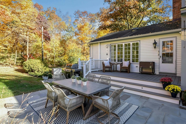 view of patio with outdoor dining space, a deck, and grilling area