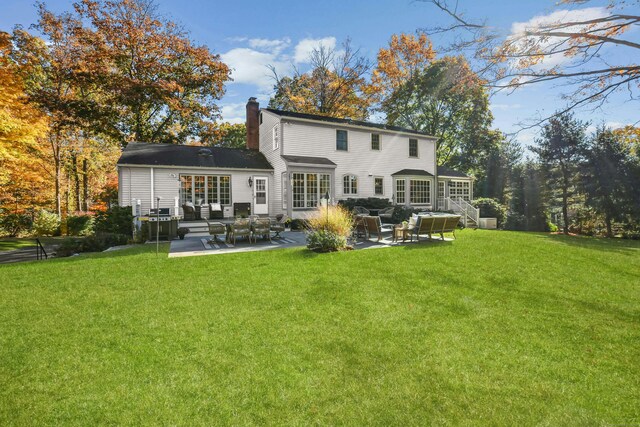 back of house with a yard, a chimney, and a patio area