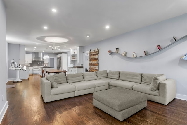 living room with a barn door and dark hardwood / wood-style floors