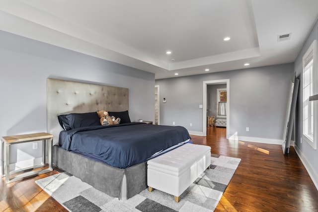 bedroom featuring dark wood-type flooring and a raised ceiling