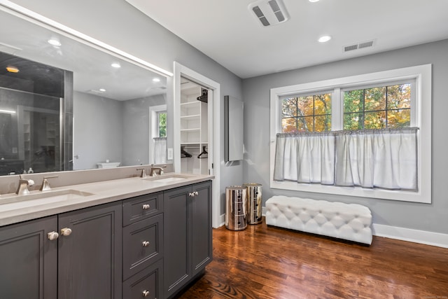 bathroom with vanity, toilet, walk in shower, and hardwood / wood-style floors