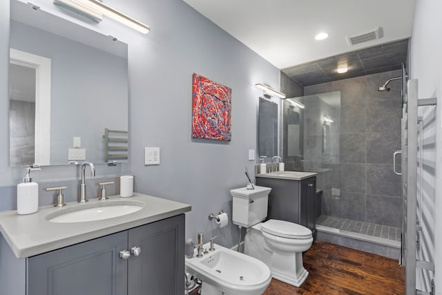 bathroom featuring vanity, hardwood / wood-style floors, toilet, and a bidet