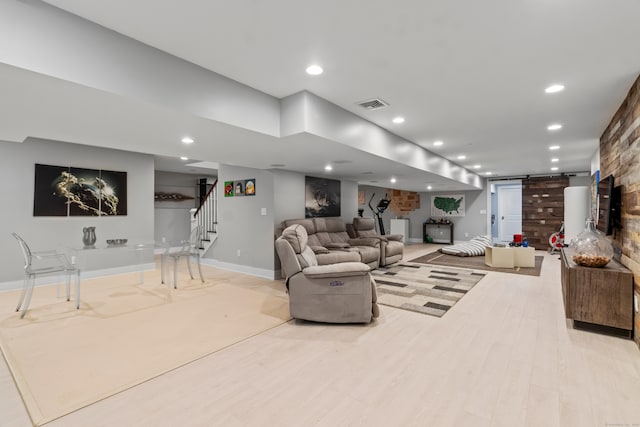 living room featuring light hardwood / wood-style floors and a barn door