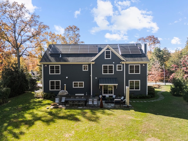 rear view of house with a patio, a lawn, an outdoor hangout area, and solar panels