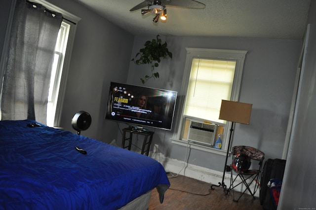 bedroom featuring lofted ceiling, cooling unit, wood-type flooring, a textured ceiling, and ceiling fan