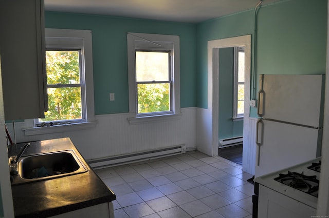 21 Violet St, Waterbury, CT 06704 - kitchen with a wainscoted wall, a sink, a baseboard radiator, and white appliances