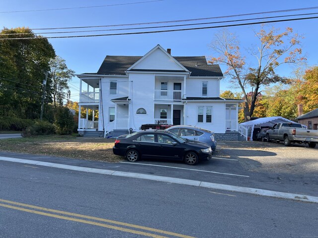 509 S Main St, Torrington, CT 06790 - view of front facade with uncovered parking, a chimney, and a balcony