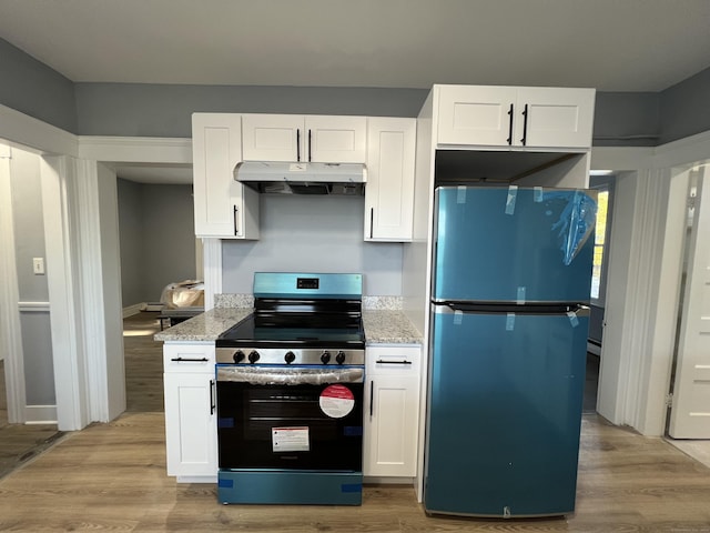 509 S Main St, Torrington, CT 06790 - kitchen featuring under cabinet range hood, light wood-type flooring, stainless steel electric range, and freestanding refrigerator