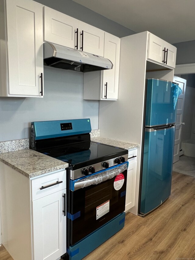 kitchen with black range with electric stovetop, refrigerator, white cabinets, and light hardwood / wood-style floors