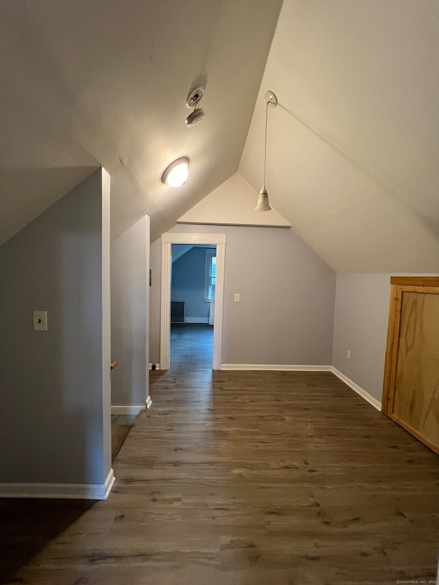 additional living space featuring vaulted ceiling and dark hardwood / wood-style floors