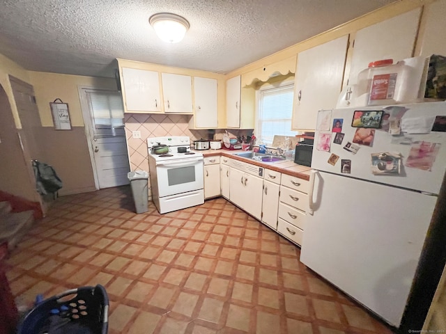 kitchen featuring a textured ceiling, tasteful backsplash, sink, white cabinetry, and white appliances