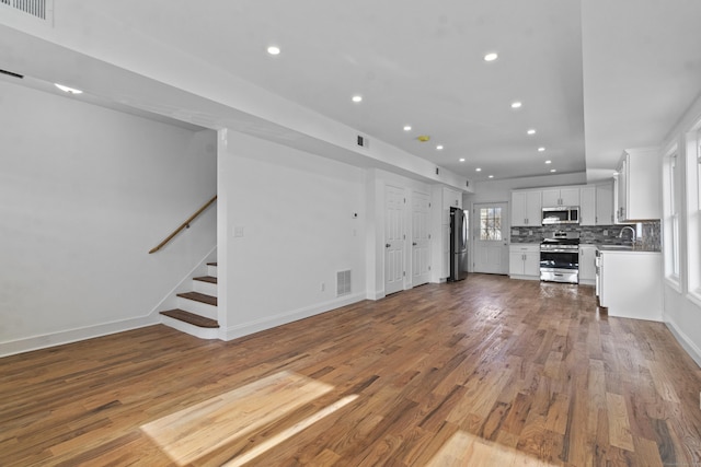 unfurnished living room featuring light hardwood / wood-style floors and sink