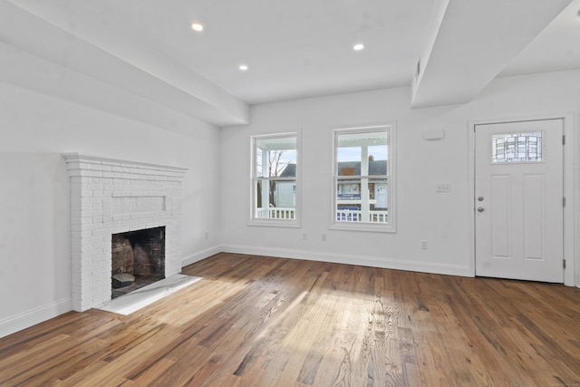 unfurnished living room with a fireplace and hardwood / wood-style floors