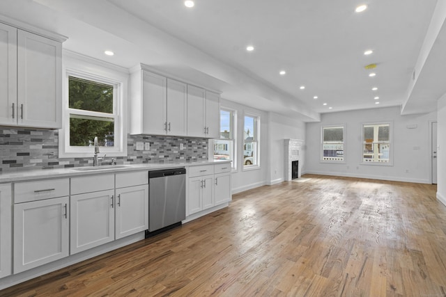 kitchen with dishwasher, white cabinetry, and sink