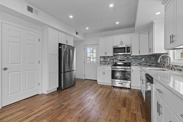 kitchen featuring a wealth of natural light, white cabinetry, sink, and appliances with stainless steel finishes