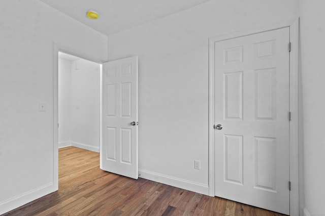 unfurnished bedroom with dark wood-type flooring