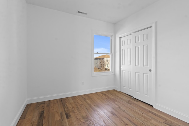 unfurnished bedroom with wood-type flooring and a closet