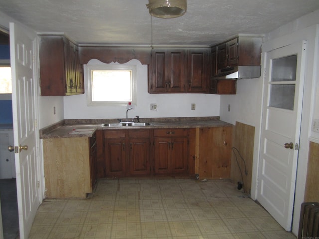 kitchen featuring sink, radiator heating unit, and a textured ceiling