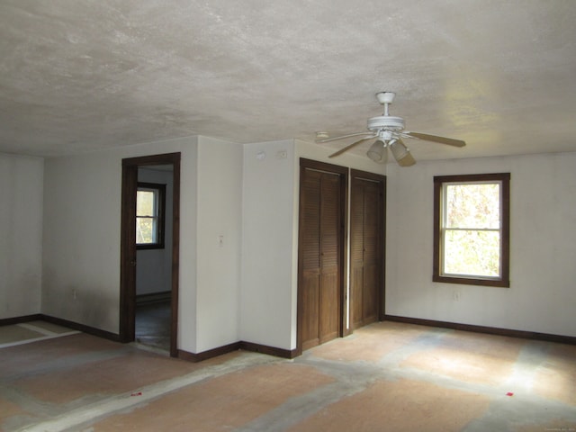 empty room with ceiling fan and a textured ceiling