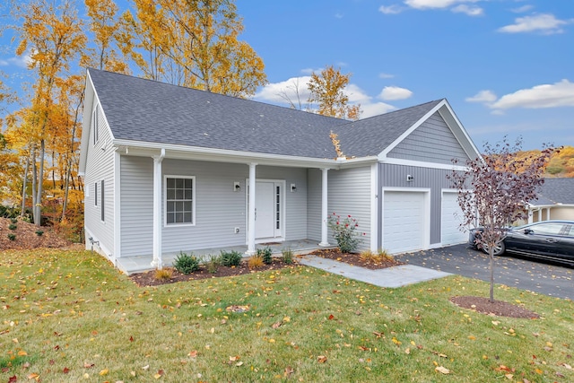 view of front facade with covered porch, a garage, and a front lawn