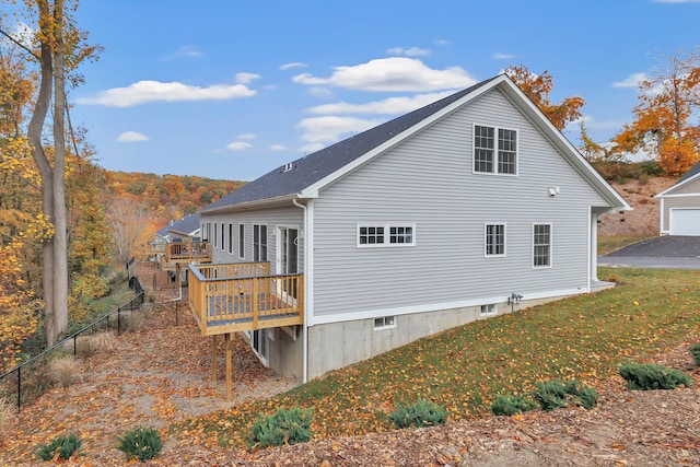 back of property featuring a lawn and a wooden deck