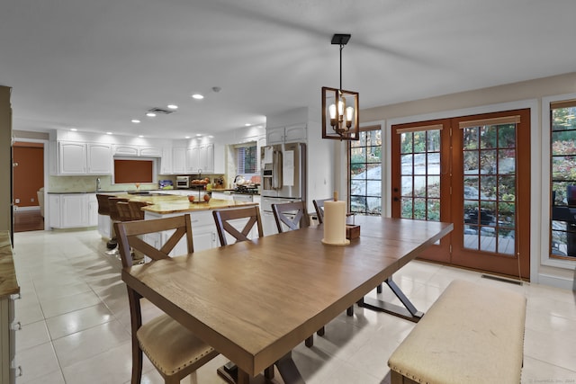 tiled dining space with a chandelier