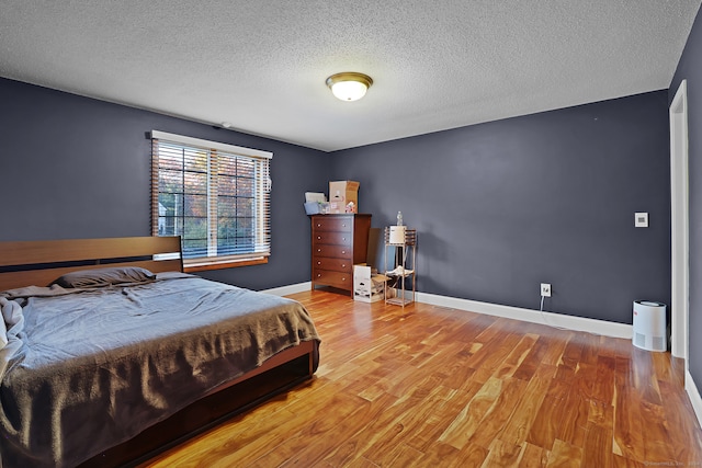 bedroom with a textured ceiling and hardwood / wood-style flooring