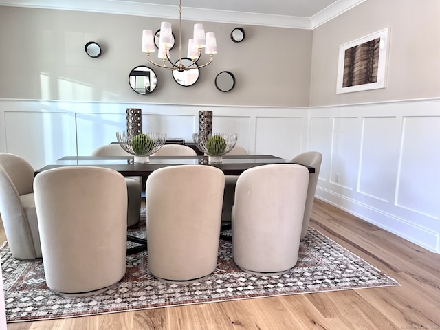 dining area with hardwood / wood-style floors, an inviting chandelier, and crown molding