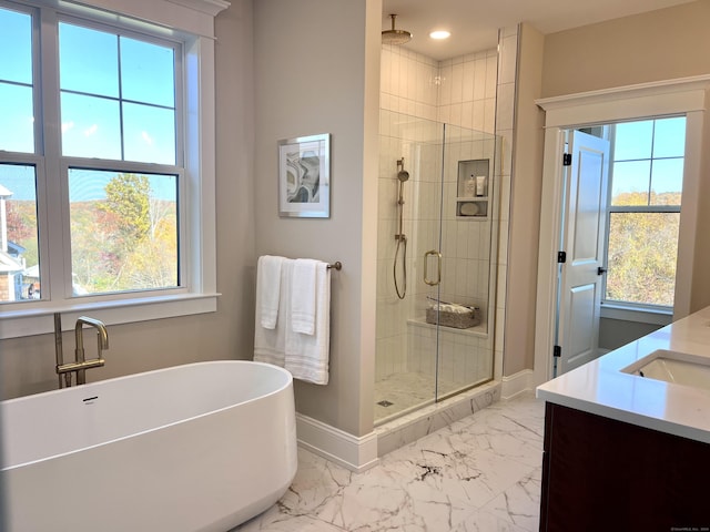 bathroom featuring vanity, separate shower and tub, and a wealth of natural light