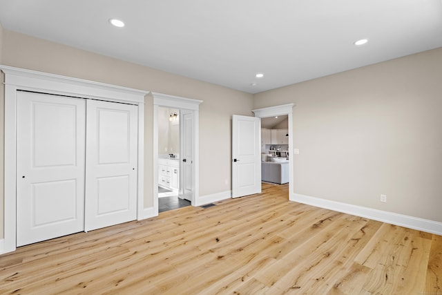 unfurnished bedroom with light hardwood / wood-style floors, a closet, and ensuite bathroom