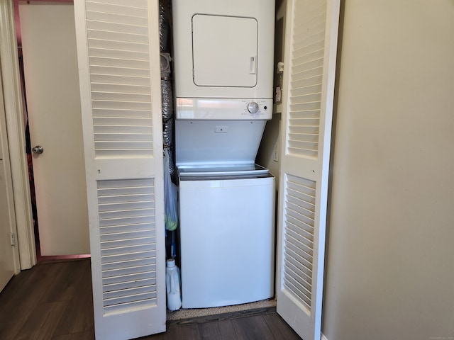 washroom with stacked washer and clothes dryer and dark wood-type flooring