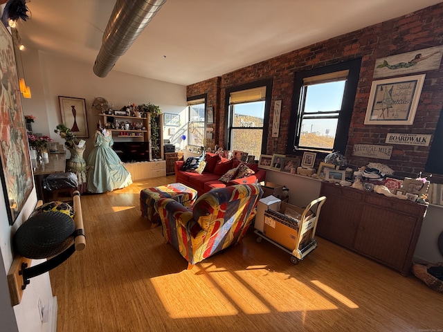 interior space with light hardwood / wood-style floors and brick wall