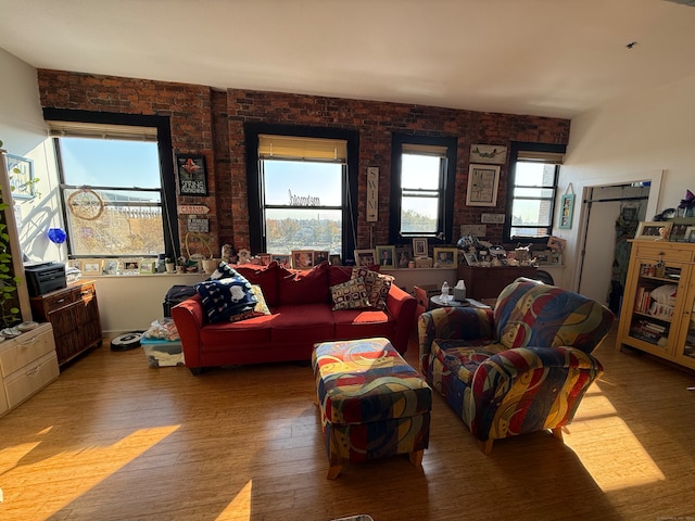 living room with brick wall and wood-type flooring