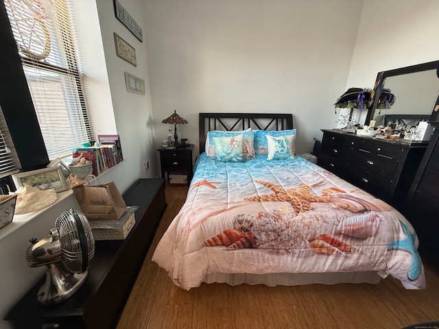 bedroom with multiple windows and dark hardwood / wood-style flooring