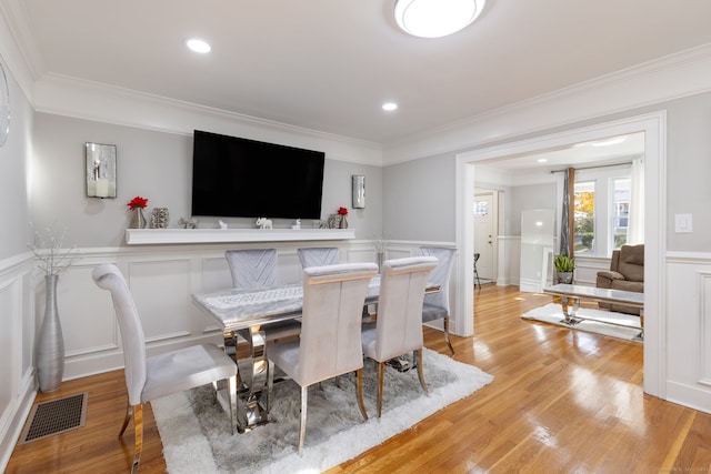 dining area featuring ornamental molding and light wood-type flooring