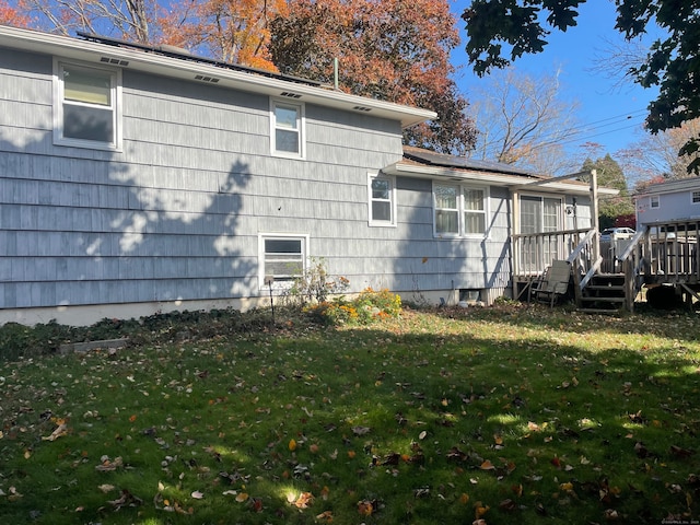 view of home's exterior featuring a lawn and a wooden deck