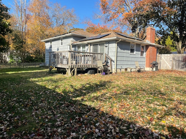 back of property featuring a yard and a deck