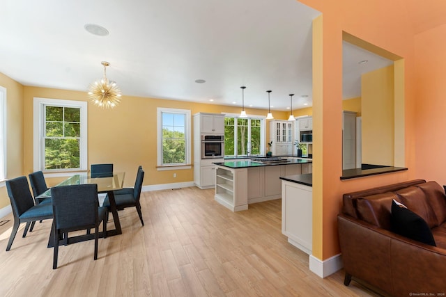 dining space featuring light wood-style floors, recessed lighting, a notable chandelier, and baseboards