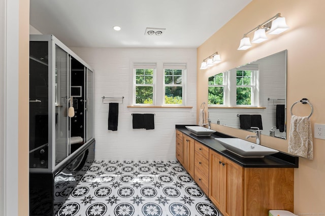 full bath featuring double vanity, a sink, and tile patterned floors