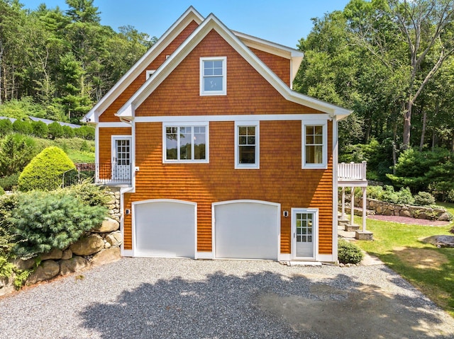 view of front of property with an attached garage and gravel driveway